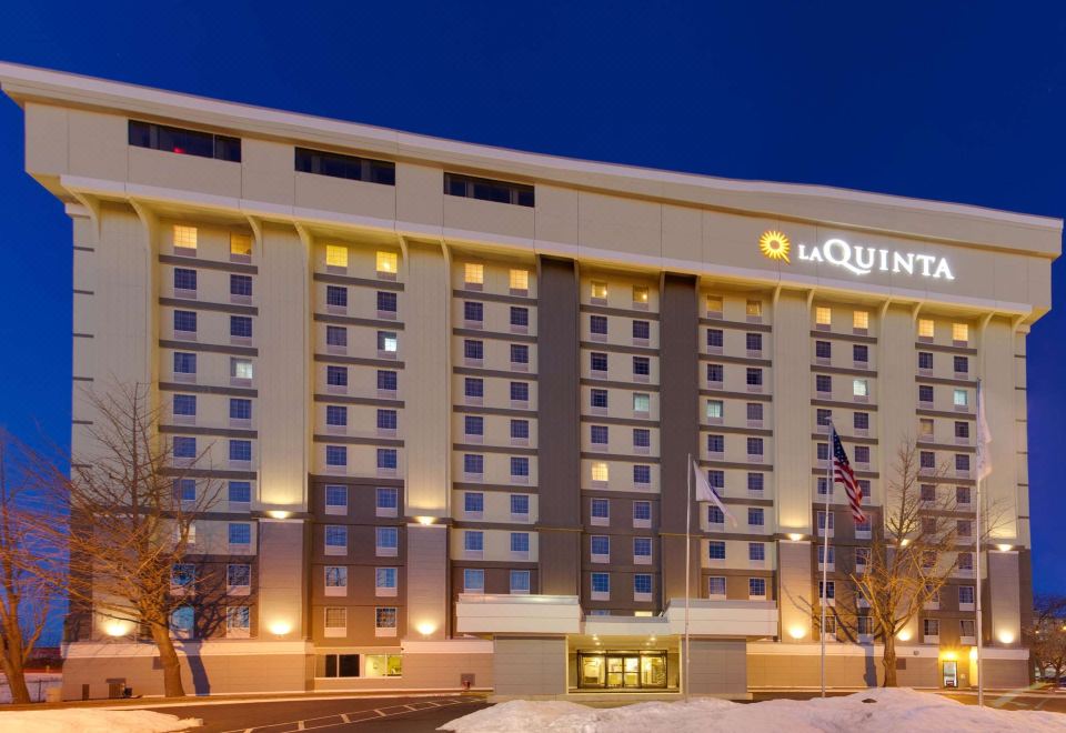 "a large hotel with a white facade and the name "" la quinta "" displayed on it" at La Quinta Inn & Suites by Wyndham Springfield MA