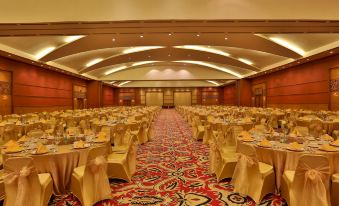 a large banquet hall with tables and chairs set up for a formal event , possibly a wedding reception at Aryaduta Palembang
