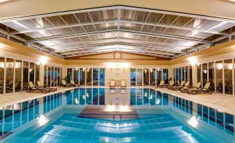 a large indoor swimming pool surrounded by lounge chairs and a wooden ceiling , providing a relaxing atmosphere at Lakeside Country Club