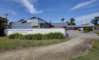 "a motel with a sign that says "" rise and shine motel "" in front of a building" at Bali Hi Motel