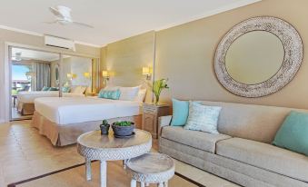 a spacious bedroom with a king - sized bed , a couch , and a dining table in the room at Bougainvillea Barbados