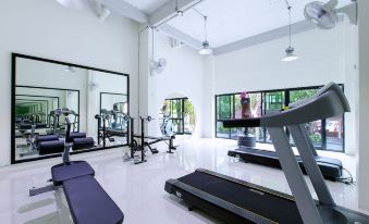 a well - equipped gym with various exercise equipment , including treadmills and weight machines , in a spacious room with large windows at Soho Boutique Hotel