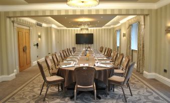 a long dining table with chairs arranged in a semicircle , providing seating for a large group of people at Grosvenor Pulford Hotel & Spa