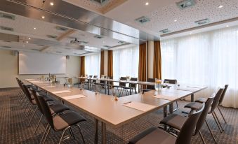 a large conference room with multiple tables and chairs arranged for a meeting or event at Radisson Hotel Zurich Airport