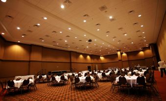 a large conference room with multiple tables and chairs set up for a formal event at Fun City Resort Hotel