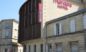 "a modern building with a curved facade and the word "" mercure "" written on it , under a clear blue sky" at Hôtel Mercure Libourne Saint-Émilion