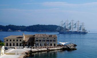 a large ship is sailing in the water near a building near a pier at Anita