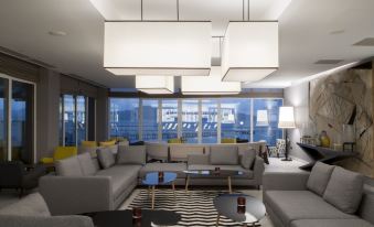 a modern living room with a large couch , coffee table , and multiple pendant lights hanging from the ceiling at Simon Hotel