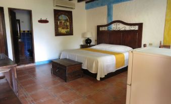 a bedroom with a large bed , wooden headboard , and a blue and white striped bedspread at Hotel La Hacienda