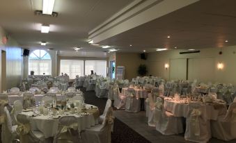 a large banquet hall with tables covered in white tablecloths and chairs arranged for a formal event at Fairway Inn