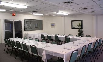 a large dining room with multiple tables set for a formal event , each table covered in white tablecloths at Fairway Inn