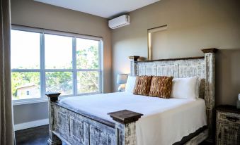 a bedroom with a large bed and white linens , a window , and a wooden headboard at Hill Country Casitas