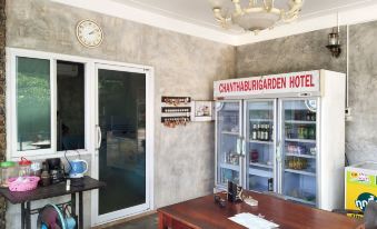 "a cozy kitchen with a table , coffee maker , and a refrigerator with the sign "" chhabinagem hotel ""." at Chanthaburi Garden Hotel