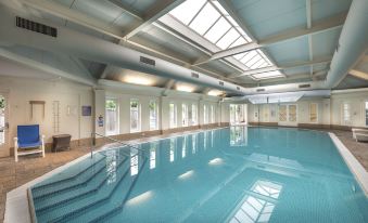 an indoor swimming pool with a large skylight , allowing natural light to fill the space at Macdonald Bath Spa Hotel