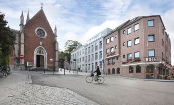 a person is riding a bicycle on a street in front of a brick building at Hotel the Shepherd