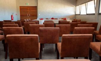 a conference room with rows of brown chairs arranged in a semicircle around a long table at Isalo Rock Lodge