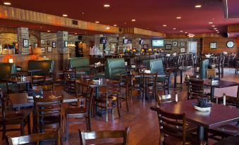 a large dining area with multiple tables and chairs , as well as a bar in the background at Thumper Pond Resort