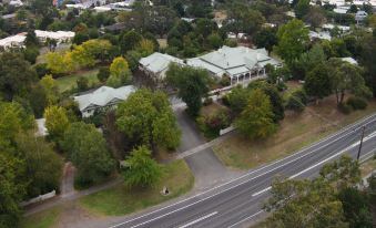 a bird 's eye view of a large house surrounded by trees and a highway in the foreground at Yarra Gables