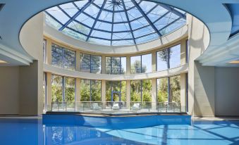 a modern swimming pool with a large , circular glass ceiling , allowing natural light to fill the space at Alkyon Resort Hotel & Spa