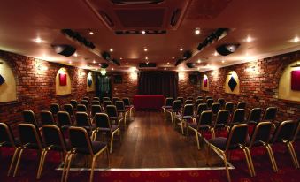 an empty conference room with rows of chairs and a red carpet , under the illumination of spotlights at Best Western Bradford Guide Post Hotel