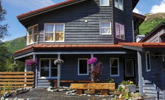 a large , gray house with a red roof and flower pots in front of it at Ski Inn