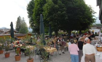 a group of people gathered around an outdoor dining area , enjoying each other 's company and socializing at Hotel Park