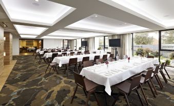 a large conference room with tables and chairs set up for a meeting or event at Flinders Hotel