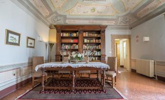 a dining room with a wooden table and chairs , surrounded by bookshelves filled with books at Hotel Villa Sermolli