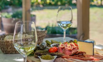 a dining table with a variety of food and wine , including cheese , meat , and vegetables at Barossa Shiraz Estate