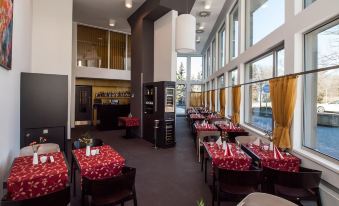 a large dining room with tables and chairs arranged for a group of people to enjoy a meal together at Hotel 99