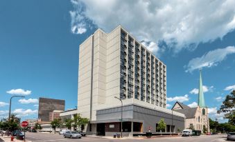 a tall , modern hotel building with a parking lot in front of it and several cars parked nearby at Holiday Inn Chicago North-Evanston, an IHG Hotel