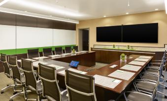 a conference room with a large table and multiple chairs arranged for a meeting or presentation at Element Fargo