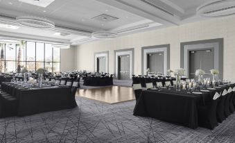 a large conference room with multiple tables and chairs , black tablecloths , and a view of the city at Courtyard Dallas Flower Mound