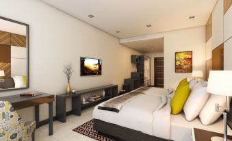 a modern bedroom with a king - sized bed , a flat - screen tv mounted on the wall , and a dresser nearby at Summit Hotel Tacloban