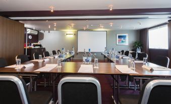a conference room set up for a meeting , with chairs arranged in a semicircle around a long table at Holiday Inn Aberdeen - West