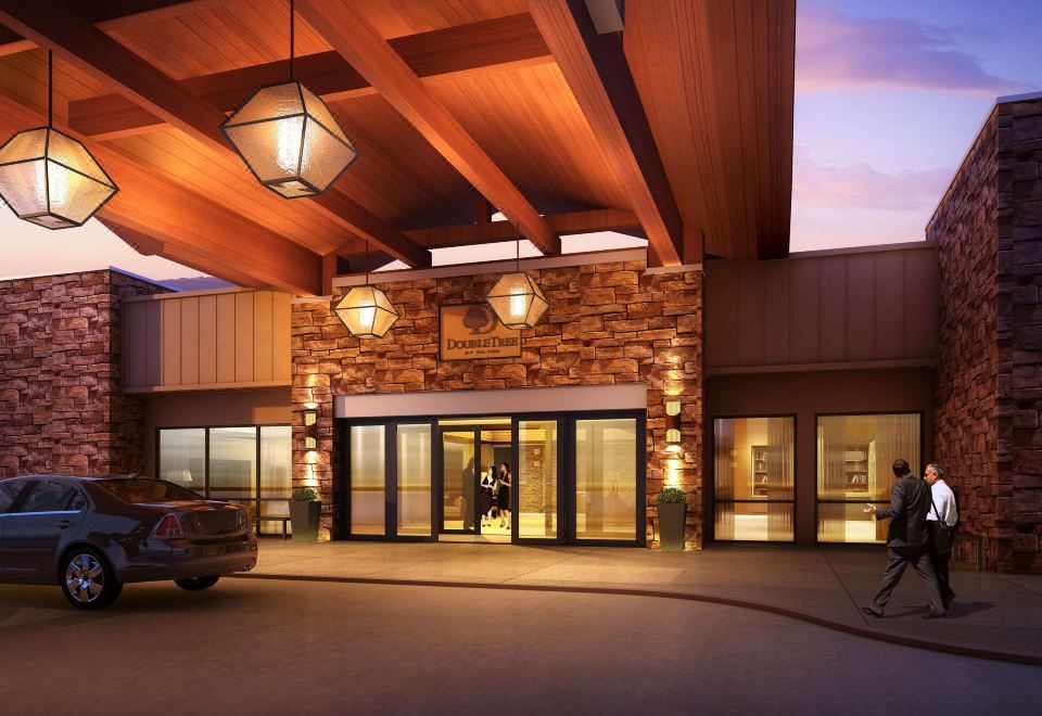 a large hotel entrance with a car parked in front and two lanterns hanging from the ceiling at DoubleTree by Hilton Hotel Pittsburgh - Green Tree