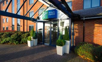 an exterior view of a holiday inn express hotel , showcasing the entrance with a sign above it at Holiday Inn Express Stafford