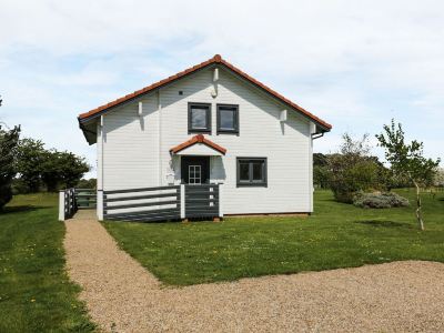 a white house with a black mailbox and a gravel driveway , surrounded by green grass at Moon Face