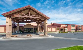 a large building with a red roof and a covered walkway leading up to it at Holiday Inn Riverton-Convention Center