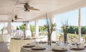 a beautifully decorated dining room with tables set for a wedding reception , surrounded by chairs and a view of the ocean at Ocean Pointe Suites at Key Largo