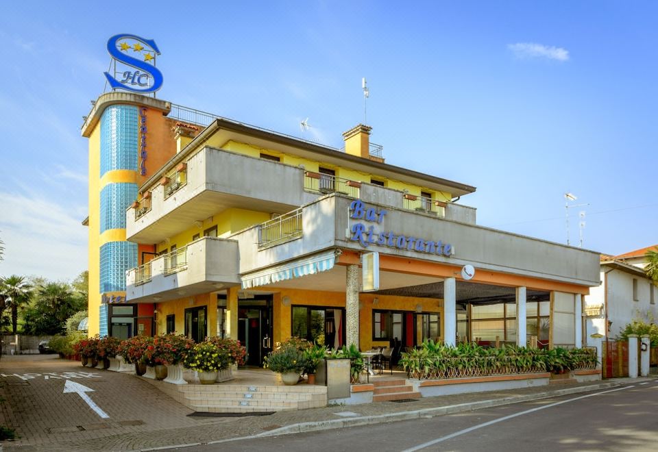 "a three - story building with a blue sign that says "" hotel villa "" is surrounded by plants" at Hotel Centrale