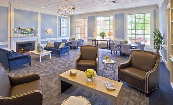 a spacious , well - lit living room with various seating options , including couches , chairs , and a coffee table at Nationwide Hotel and Conference Center