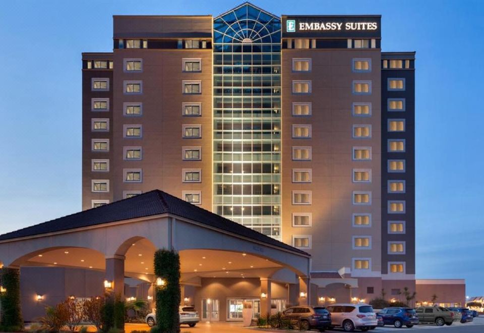 a large hotel building with a parking lot in front of it , illuminated at night at Embassy Suites by Hilton Monterey Bay Seaside