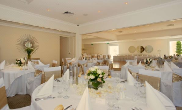 a well - decorated dining room with tables covered in white tablecloths and chairs arranged around them at Brooklands of Mornington
