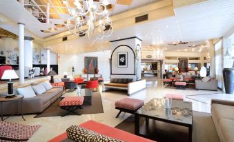 a large , modern living room with multiple couches and chairs arranged in various positions , creating a cozy and inviting atmosphere at Occidental Fuengirola