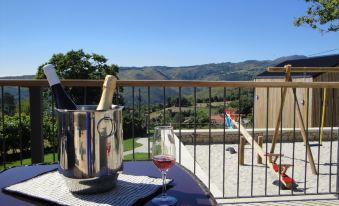 a wine glass with a cork and a bottle of champagne on a table , with a view of the countryside in the background at Casa de Lobos