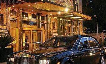 "a black rolls - royce phantom parked in front of a building , illuminated at night , with the brand name "" rolls - royce "" visible" at Four Seasons Hotel Cairo at the First Residence
