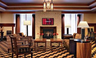 a cozy living room with a fireplace , several chairs , and a tv mounted on the wall at Ameristar Casino Black Hawk