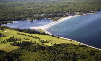 a scenic view of a beach with grassy hills and water , taken from an aerial perspective at White Point Beach Resort