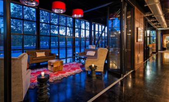 a modern living room with large windows , red lanterns hanging from the ceiling , and comfortable seating at Hotel Nyack, A Joie de Vivre Hotel by Hyatt